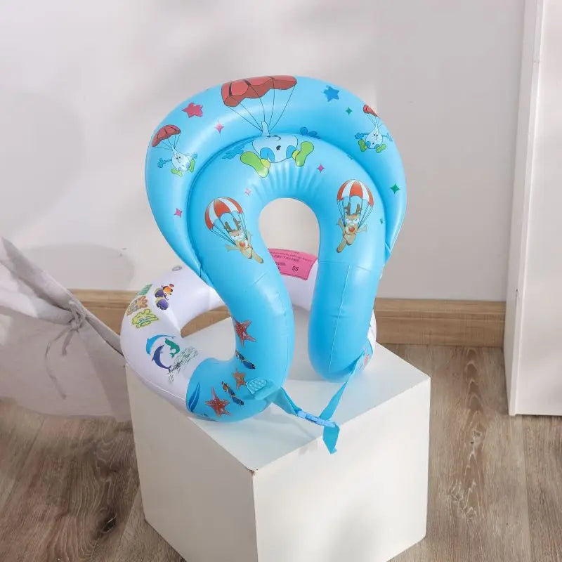 A blue inflatable swim neck ring with cartoon designs, placed on a white stand.