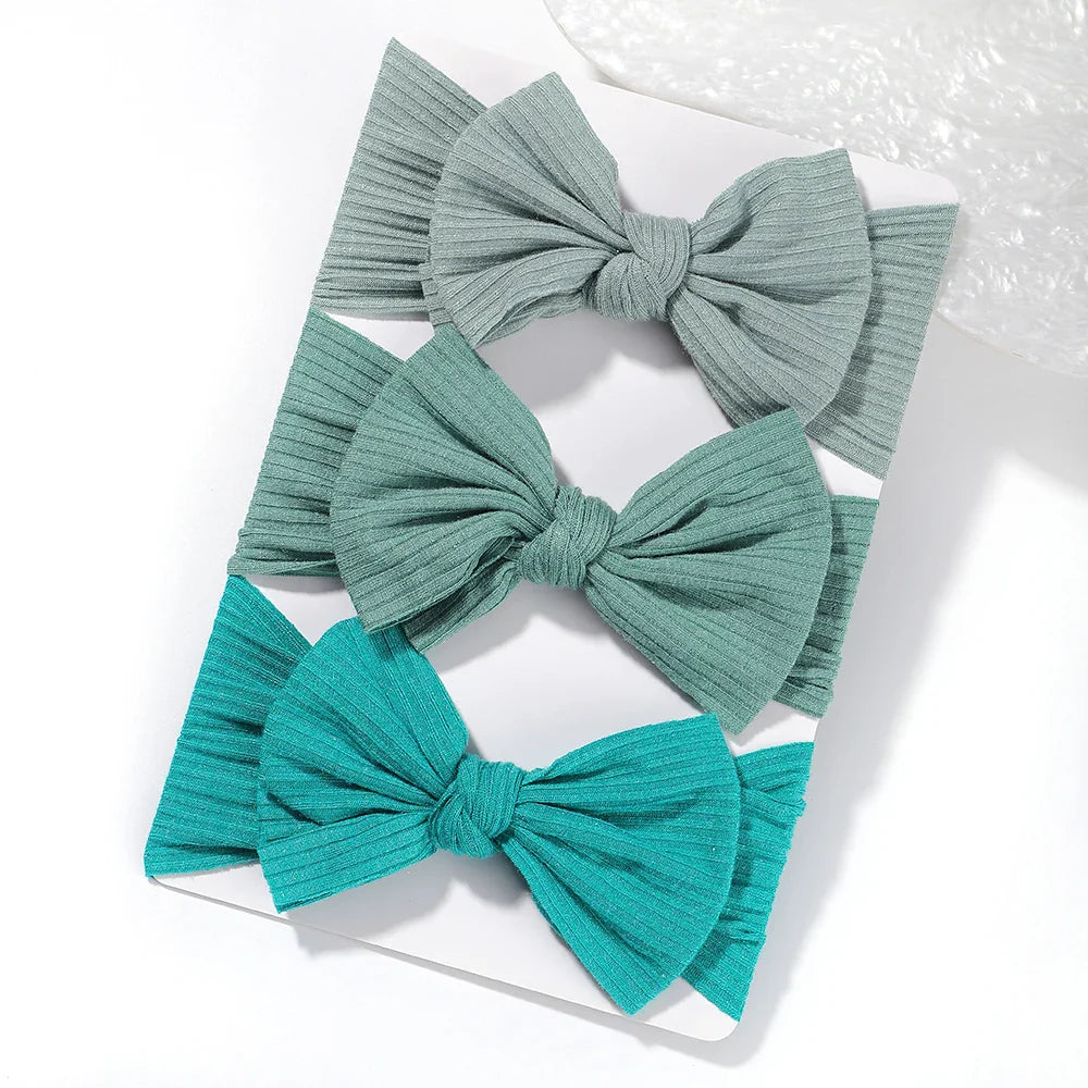 A set of 3 Baby Bow Headbands with different colors.