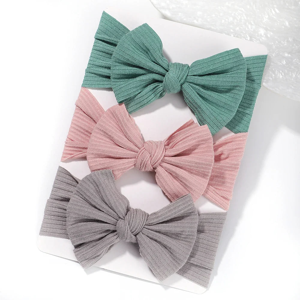 A set of 3 Baby Bow Headbands with different colors.