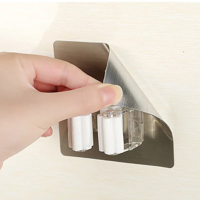 A close-up of a person peeling the backing off an adhesive hook before sticking it to a wall.