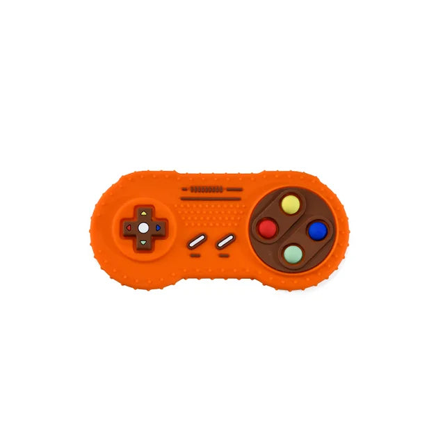 An orange silicone teether shaped like a classic game controller with colorful buttons.