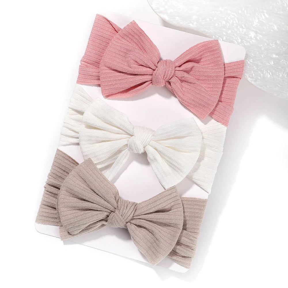 A set of 3 Baby Bow Headbands with different colors.