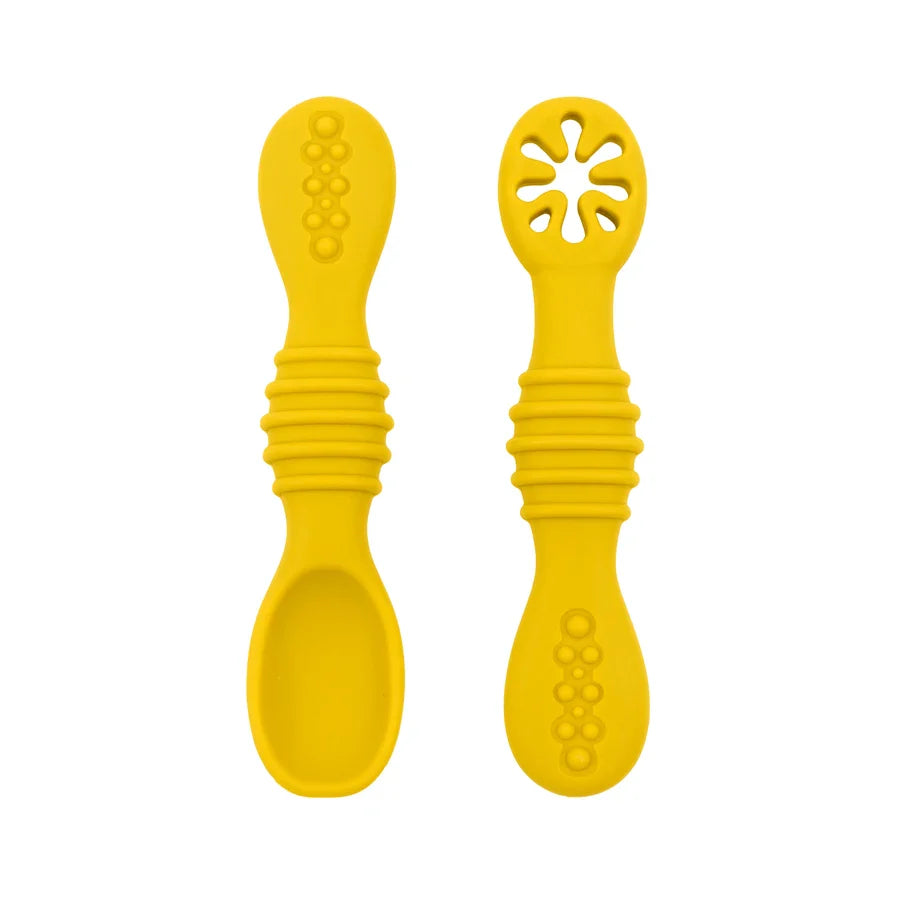 A close-up of two yellow baby spoons, one with a regular spoon shape and the other with a cut-out flower design, against a white background.