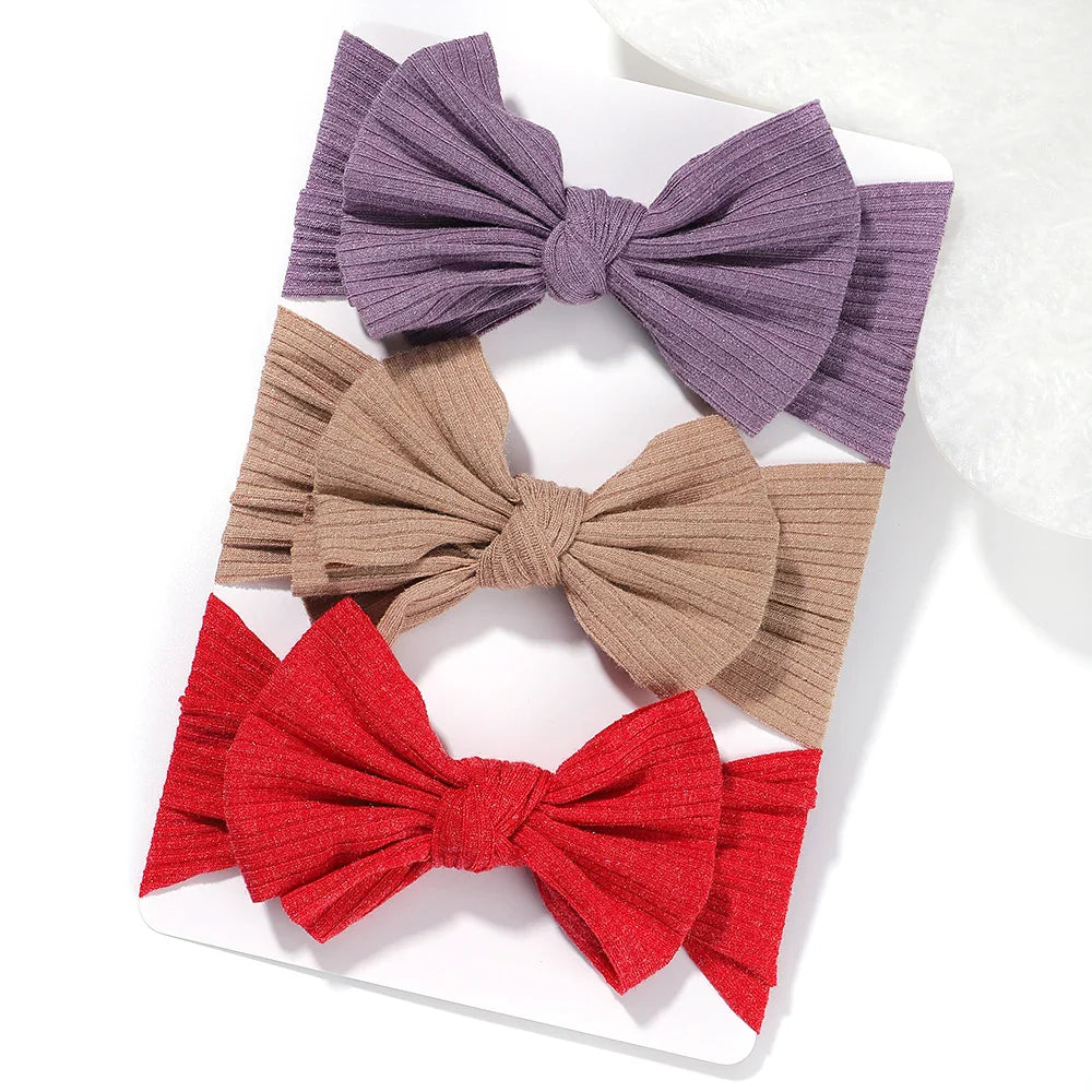 A set of 3 Baby Bow Headbands with different colors.