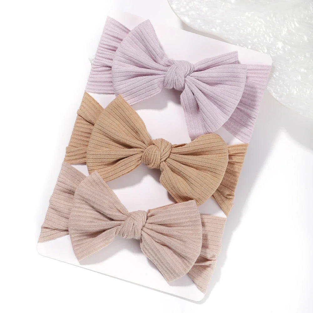 A set of 3 Baby Bow Headbands with different colors.