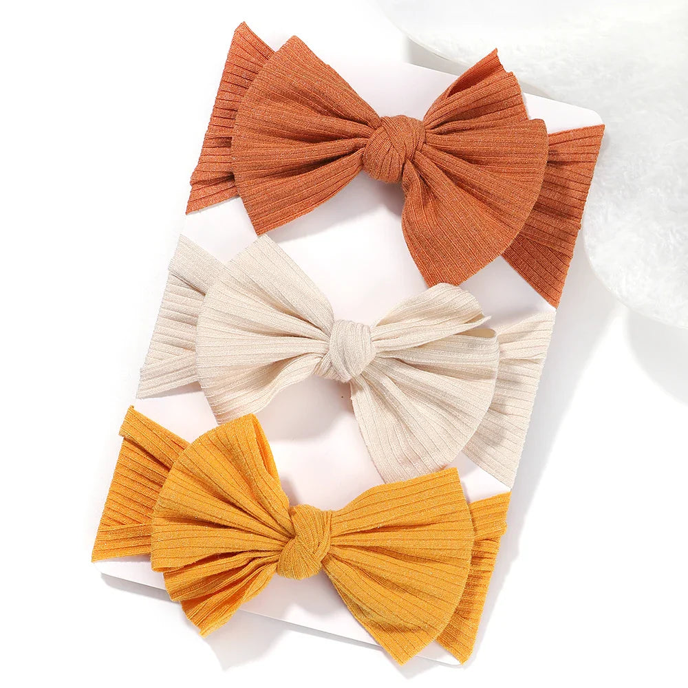 A set of 3 Baby Bow Headbands with different colors.